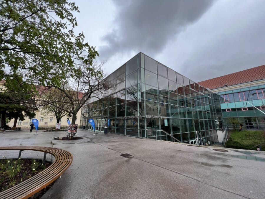 Foto des Außenbereichs vor einem kubischen Gebäude mit Glasfassade